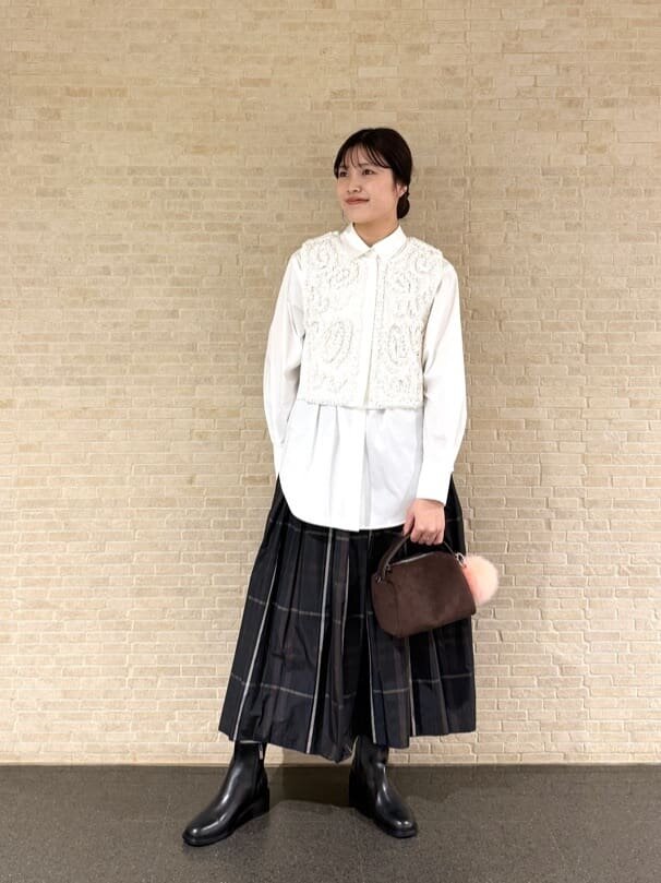 シャツとプリーツスカートを着た女性