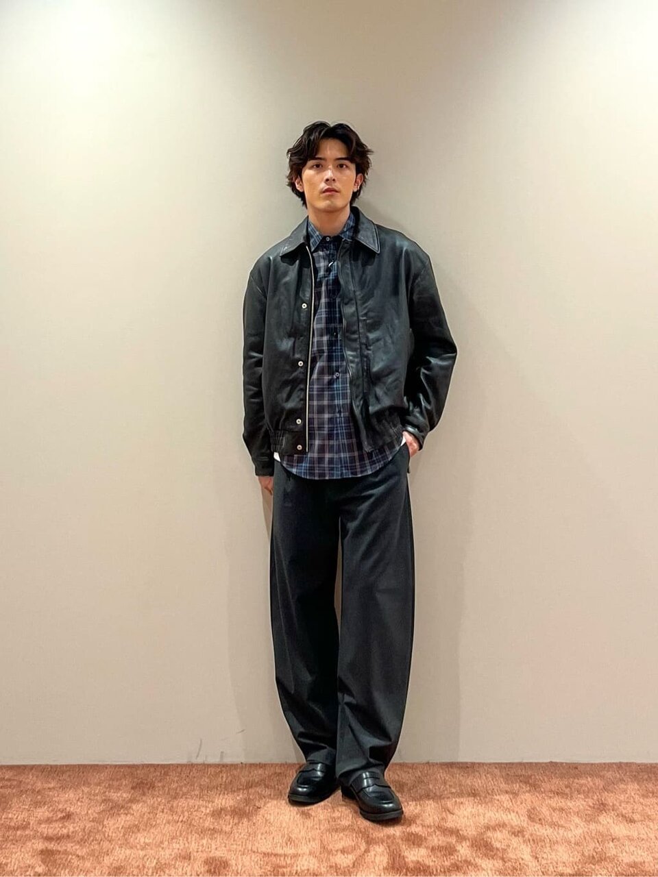 レザージャケットとグレーのパンツを着た男性