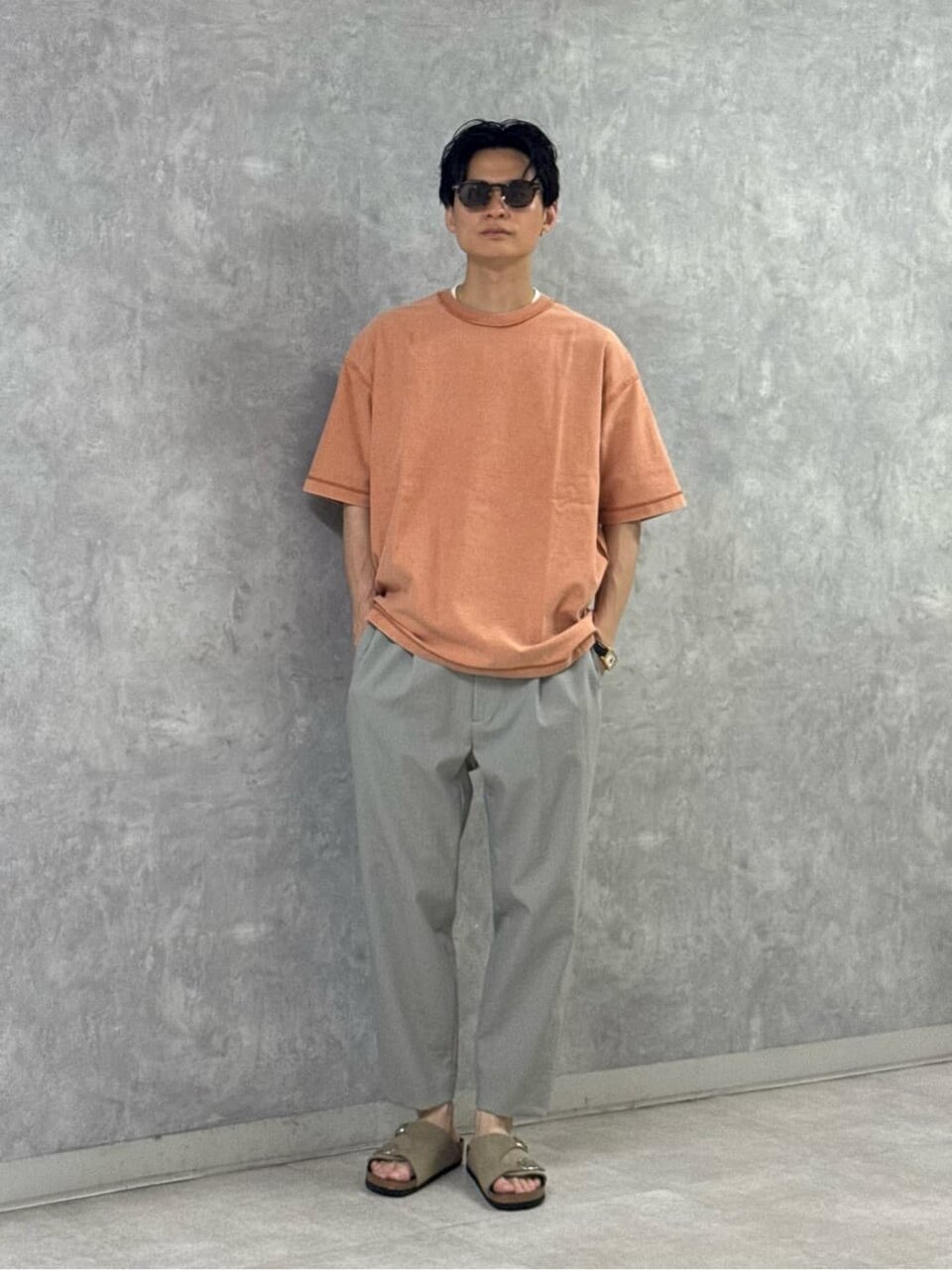 Tシャツとグレーのパンツを着た男性