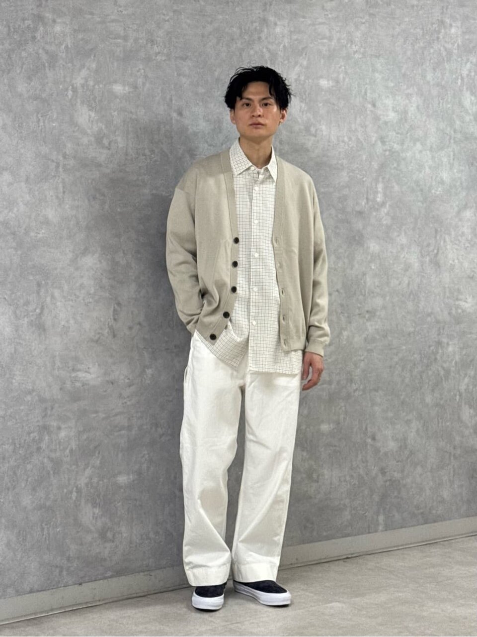 カーディガンとワイドパンツを着た男性