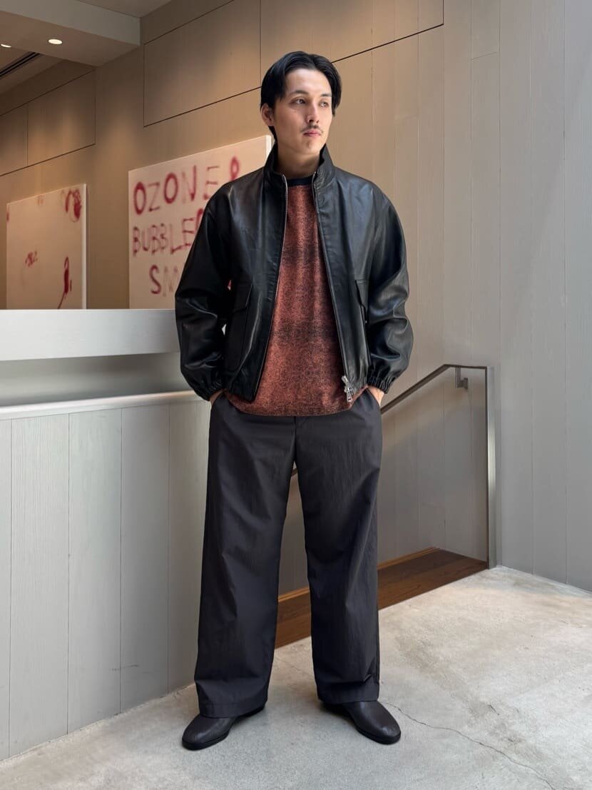 レザージャケットとスラックスを着た男性