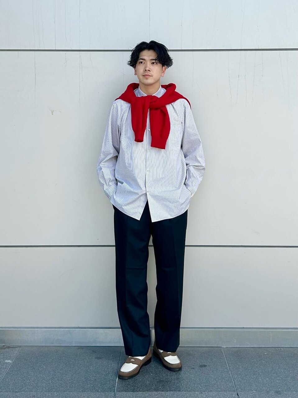 ストライプシャツとスラックスを着た男性