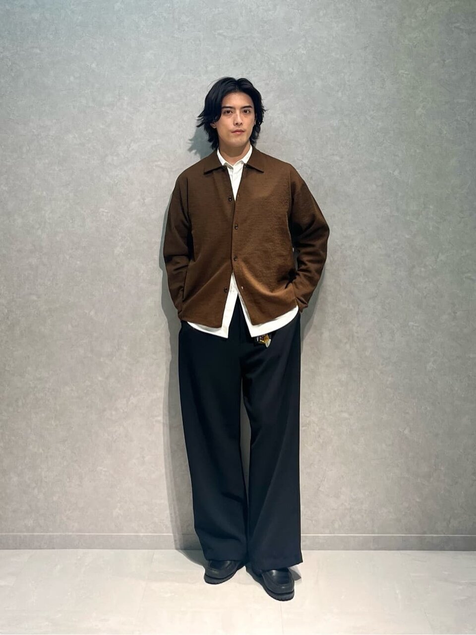 ニットシャツとワイドパンツを着た男性