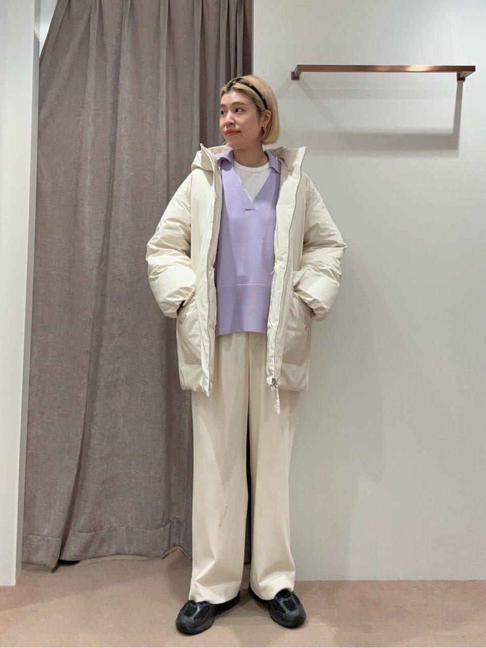 白のダウンジャケットと紫のニットを着た女性