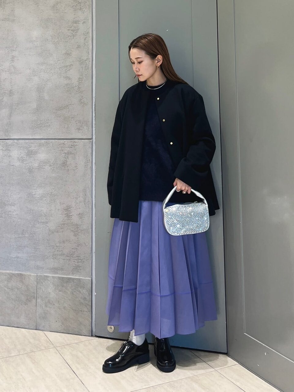 紫のスカートと黒いコートを着た女性