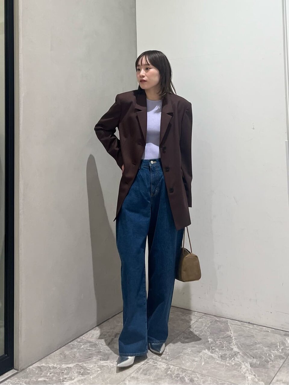 紫のニットとジャケットを着た女性