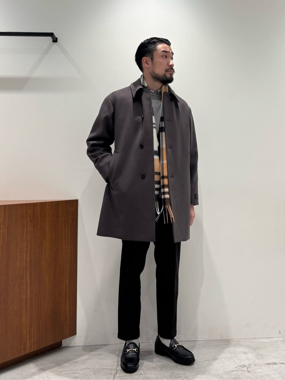 ステンカラーコートとスラックスを着た男性