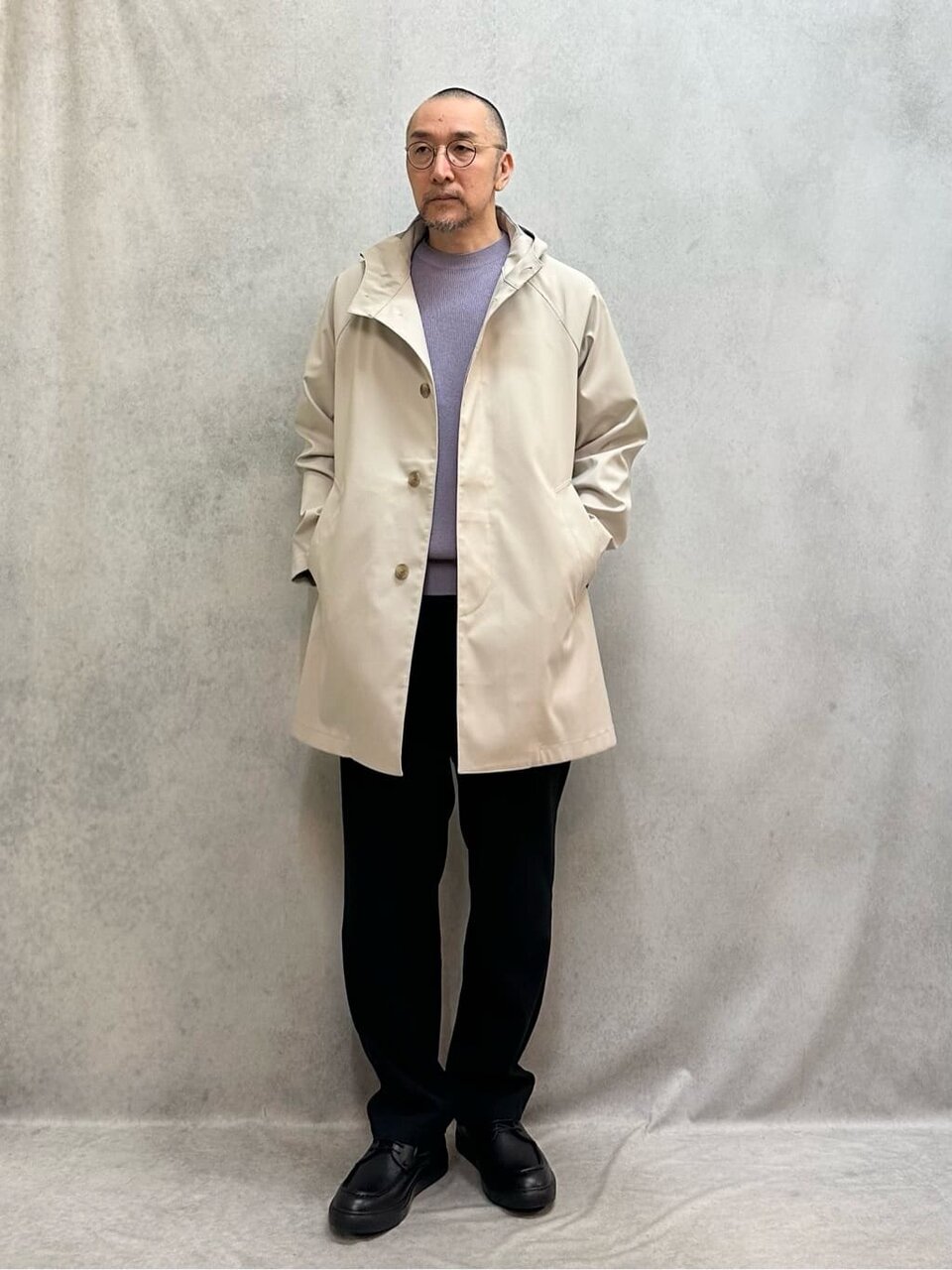 フードコートとスラックスを着た男性