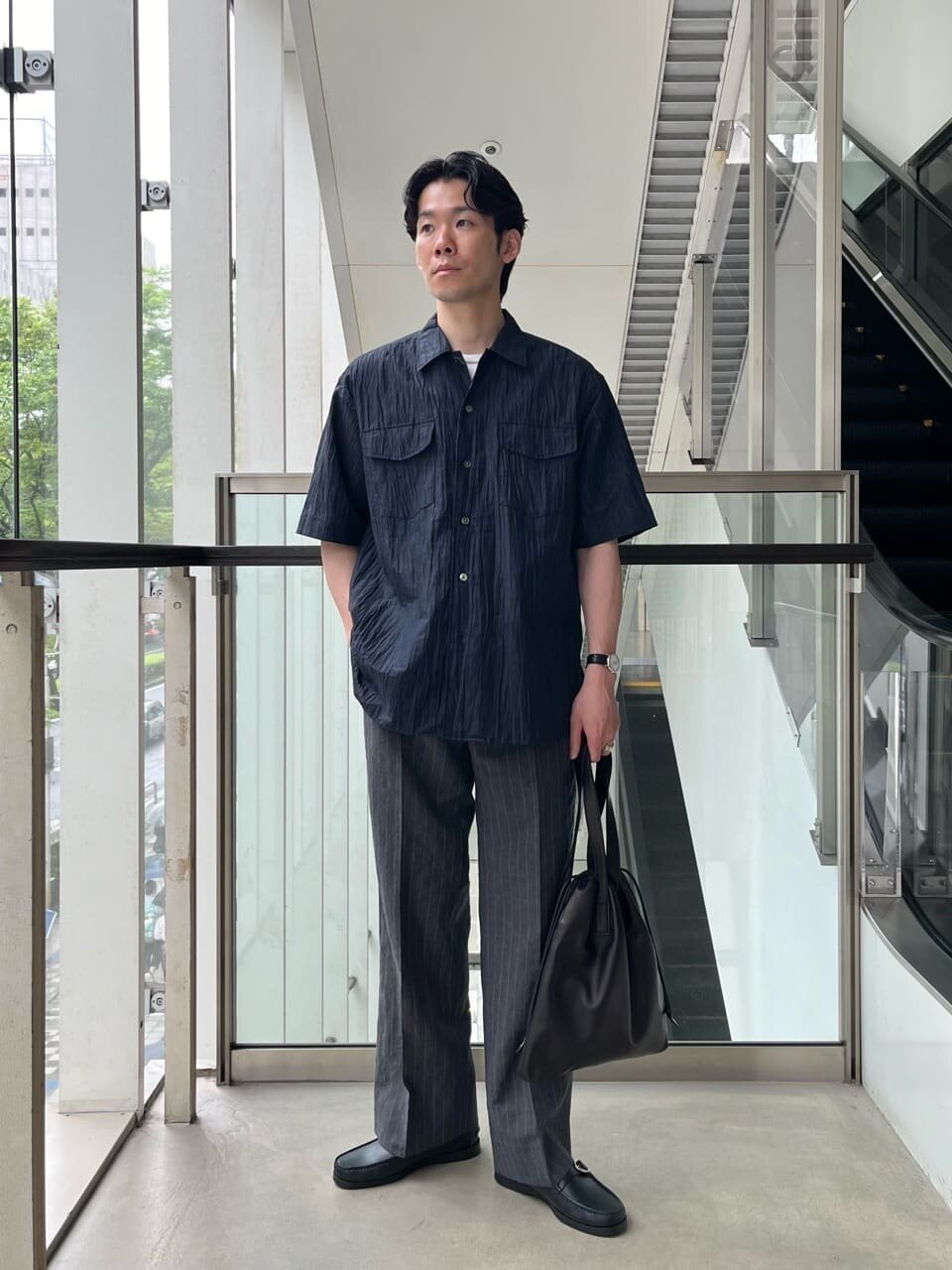 オープンシャツとスラックスを着た男性