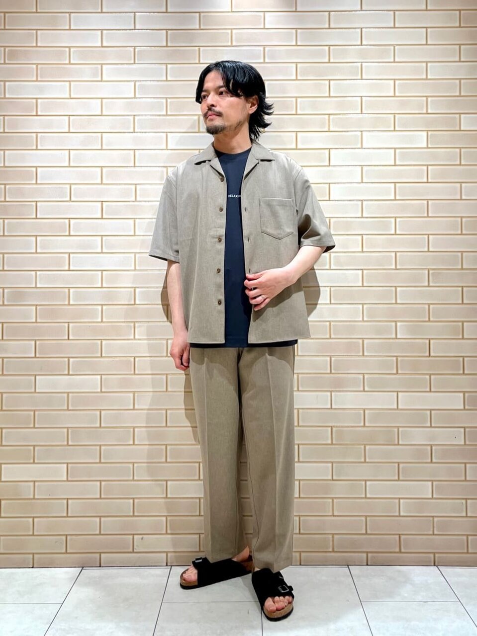 シャンブレーシャツのセットアップを着た男性