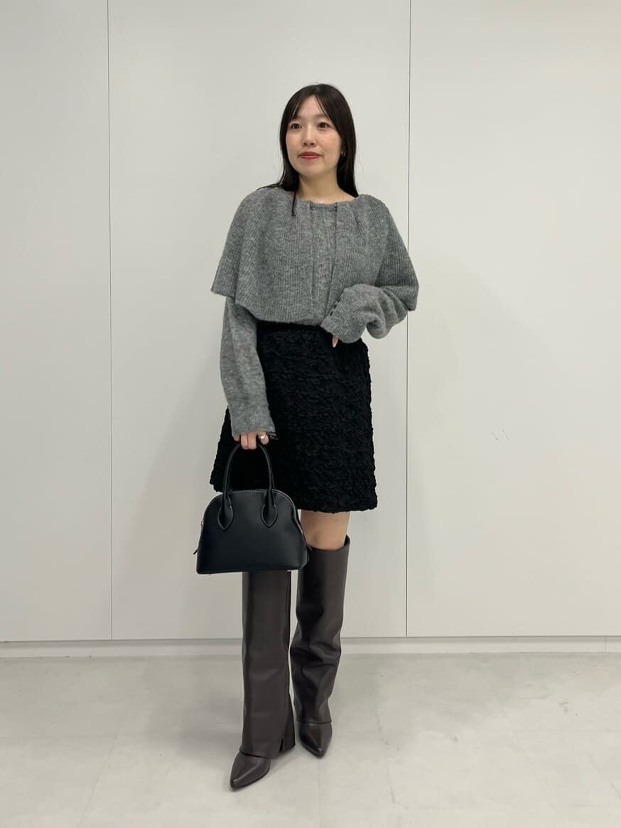 ケープデザインニットを着た女性