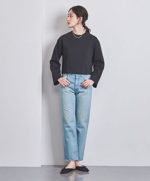 ストレートのデニムパンツをはく女性