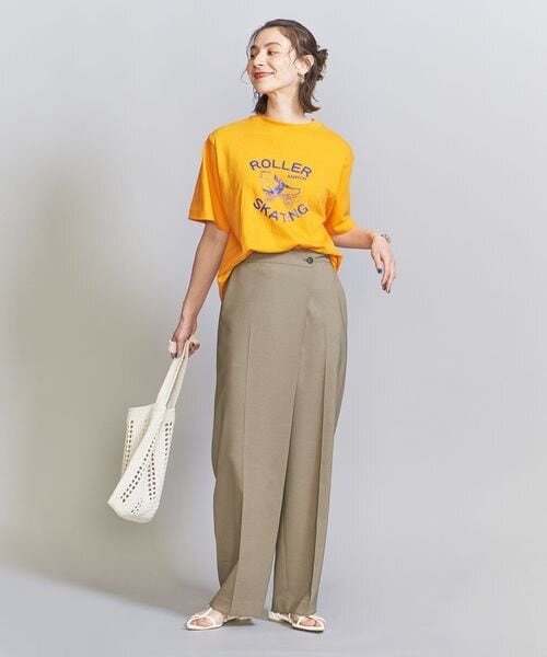 ラップデザインのワイドパンツをはく女性