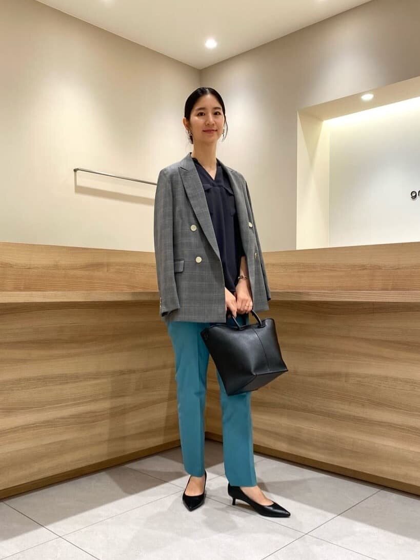 ケリーグリーンのスティックパンツ×チェック柄のジャケットのコーデ