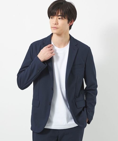 ネイビーのテーラードジャケットを着る男性