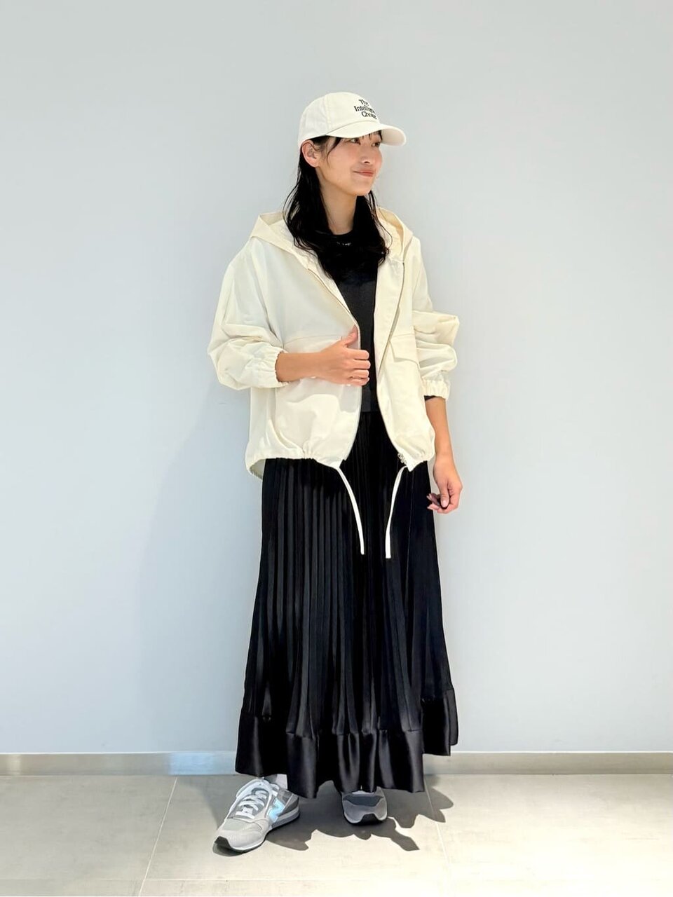 白いパーカーと黒いスカートを着た女性