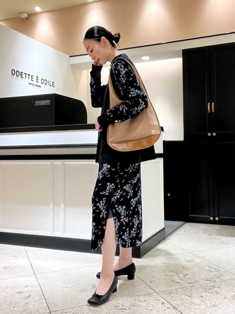 花柄のワンピースとパンプスを身につけた女性