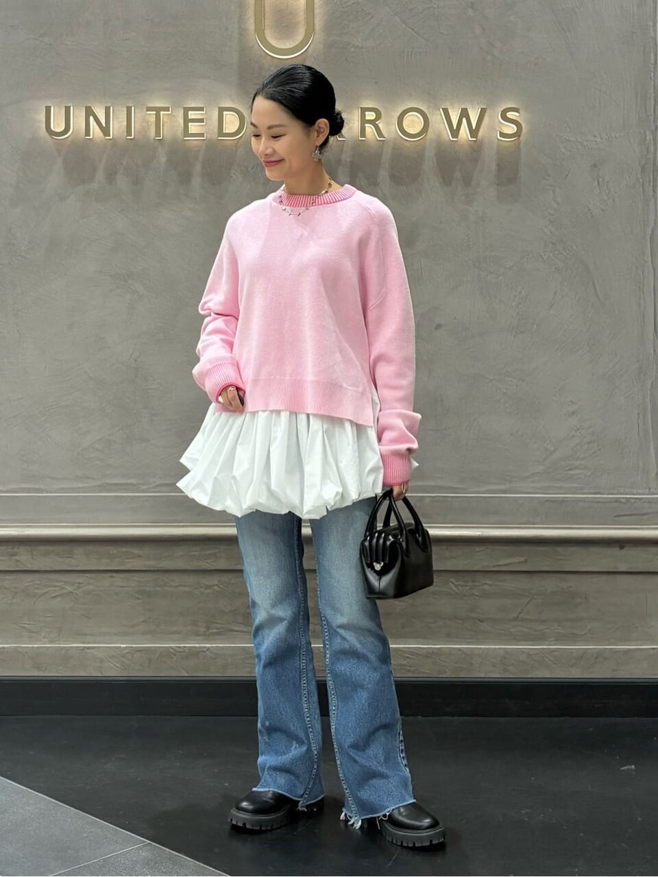 ピンクのニットをレイヤードした女性