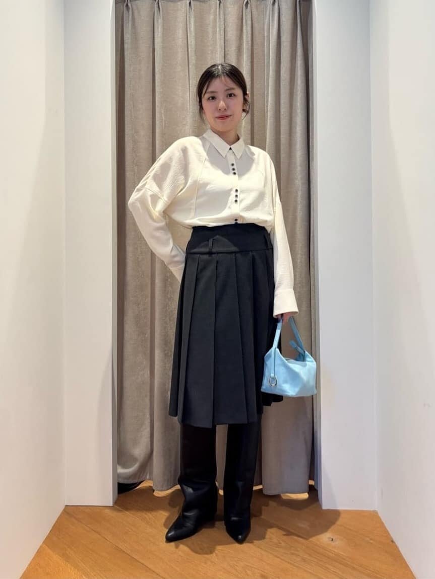 白シャツとプリーツスカートを着た女性