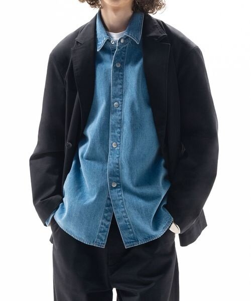 スーツにデニムシャツを合わせた男性