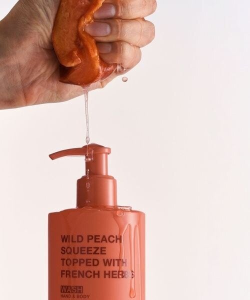 ピンクのボトルに液体を絞る手元