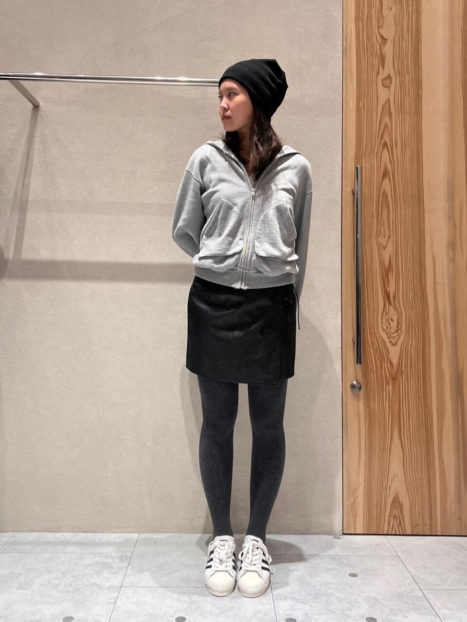 フーディーとレザーライクミニスカートの20代コーデ