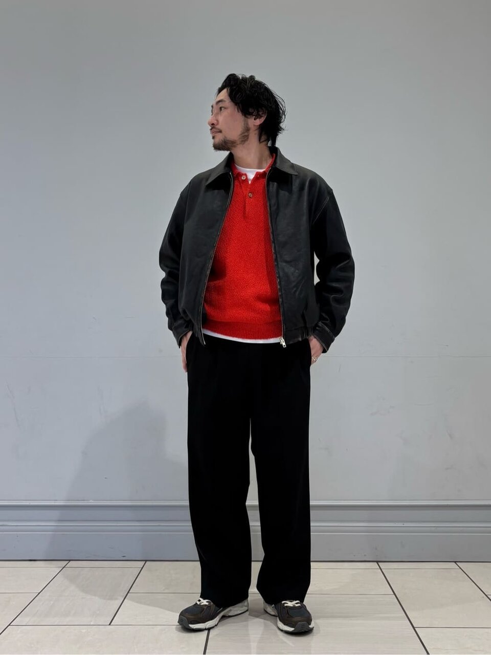 黒のレザージャケットに黒のパンツをあわせた男性