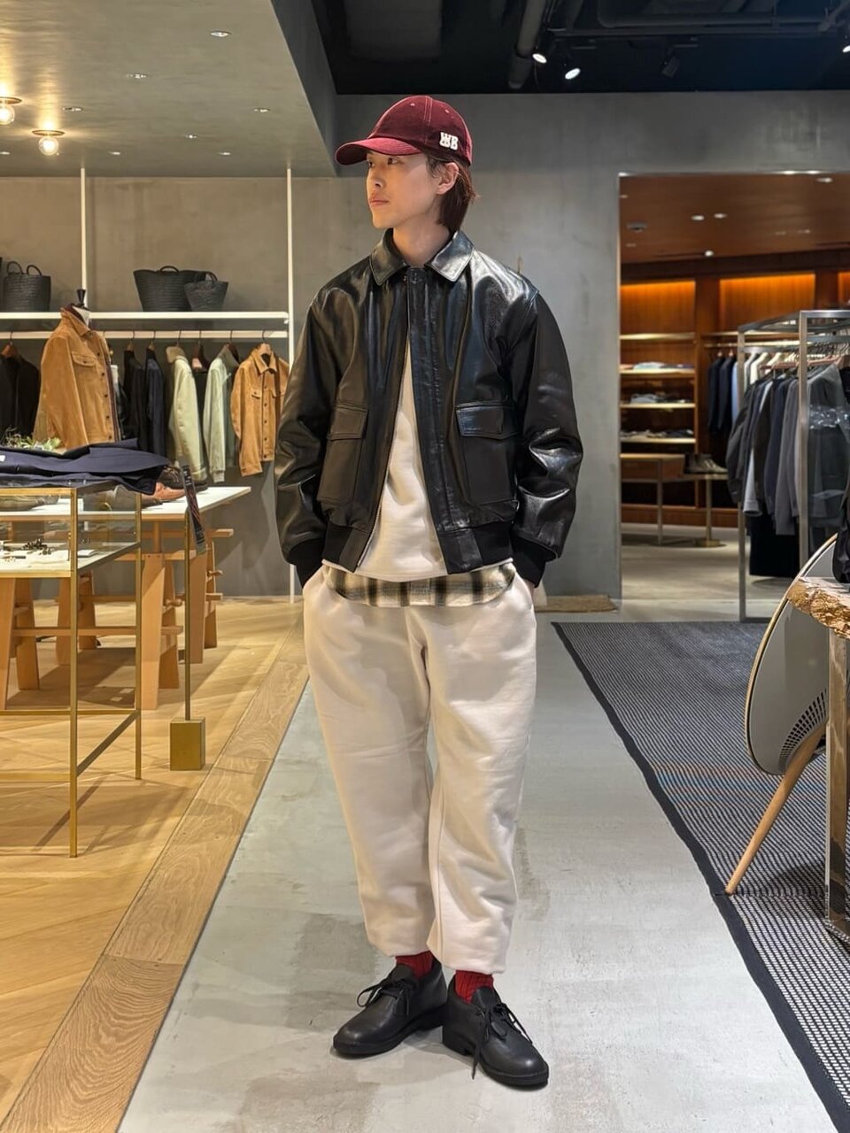 黒のレザージャケットに帽子をあわせた男性