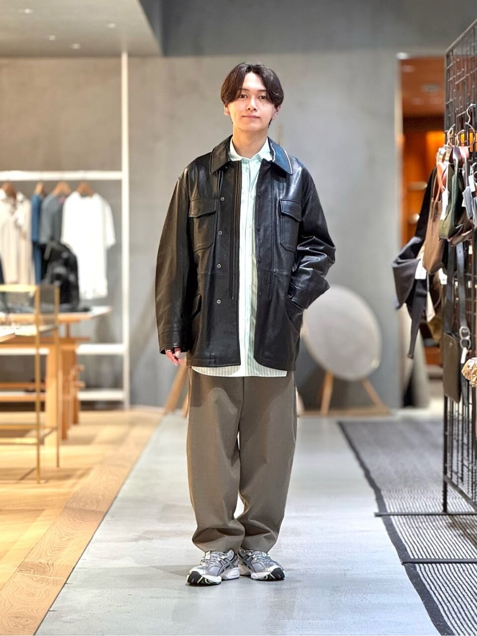 ダークブラウンのレザージャケットにオリーブカラーのパンツをあわせた男性