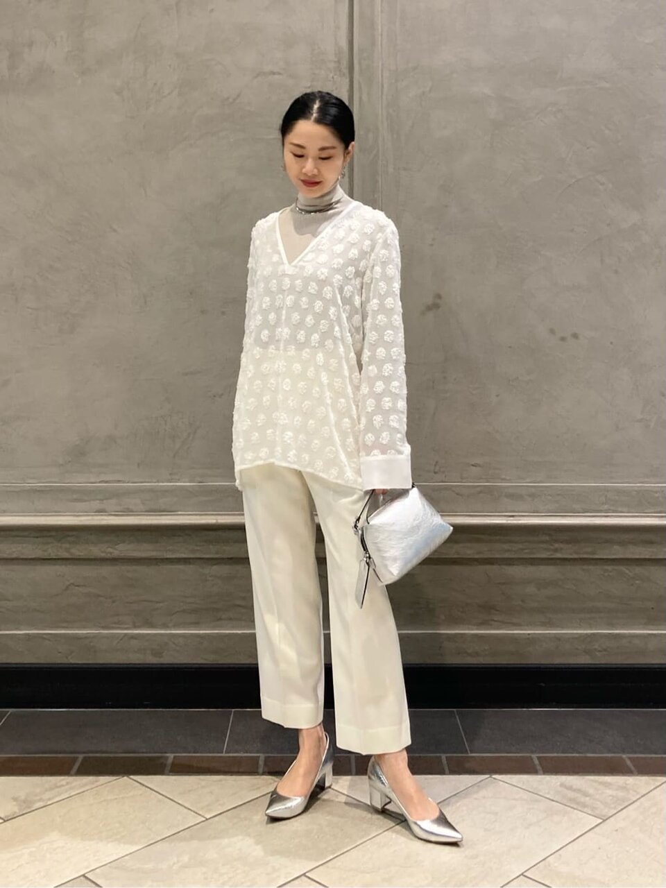 オフホワイトのブラウスを着た女性