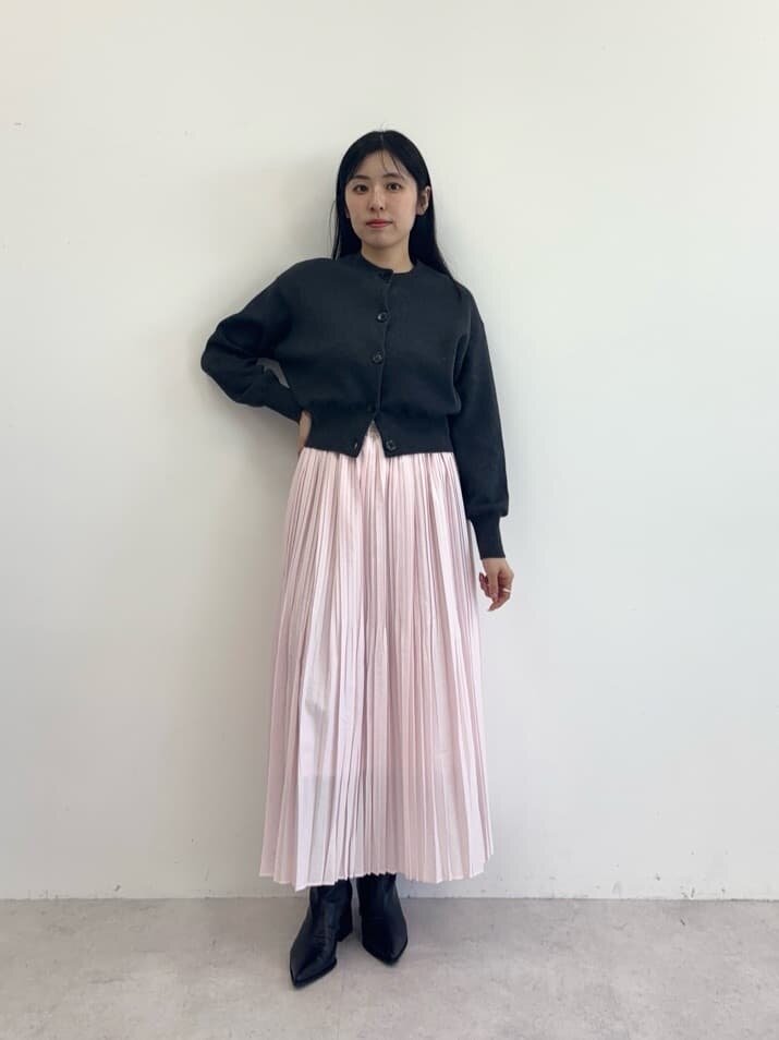 カーディガンにスカートをあわせた女性