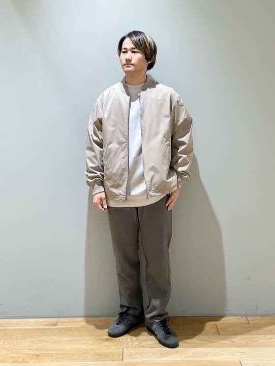 ベージュのブルゾンを羽織っている男性