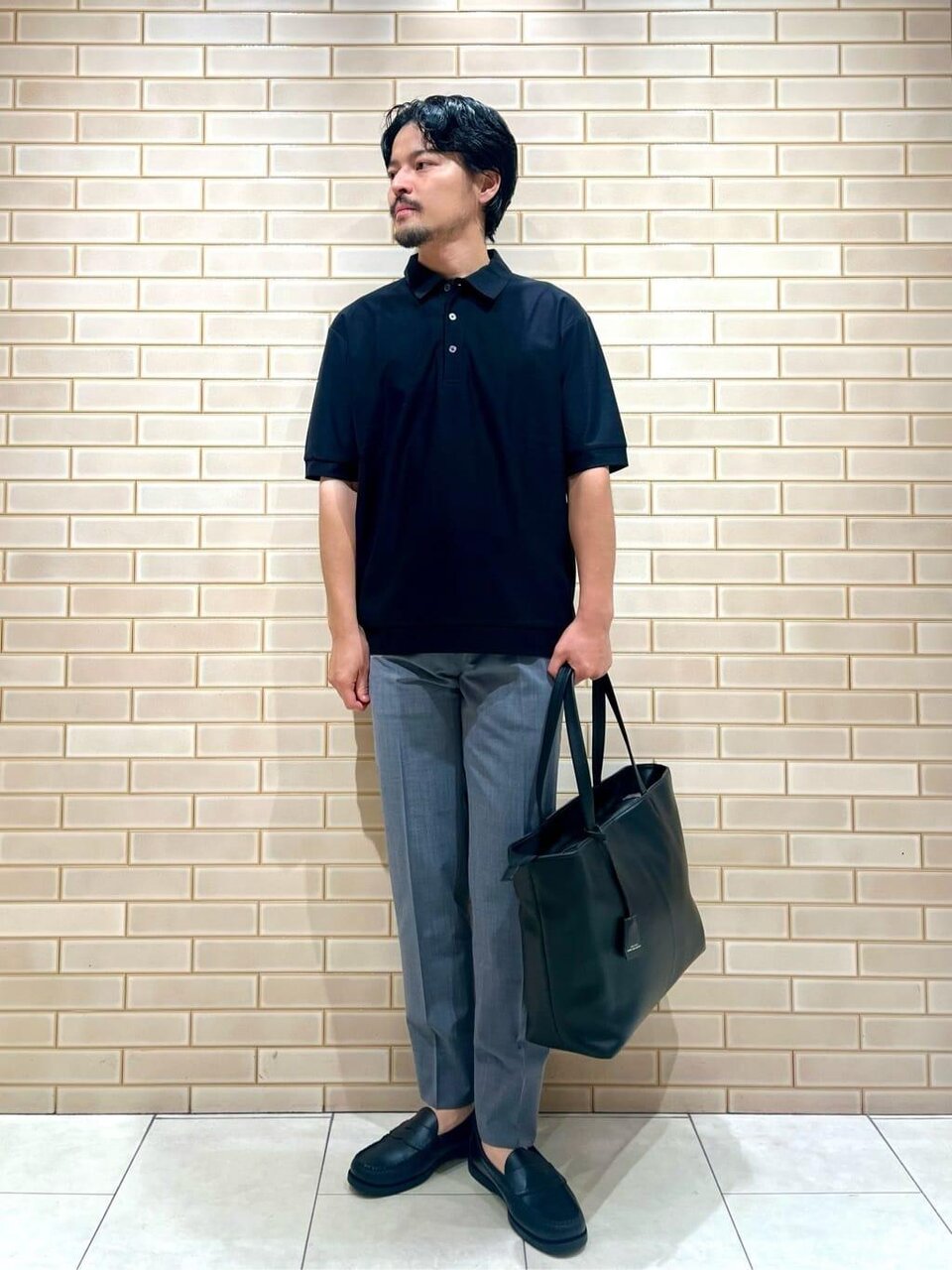 黒のポロシャツ×ダークグレーのパンツのコーデ