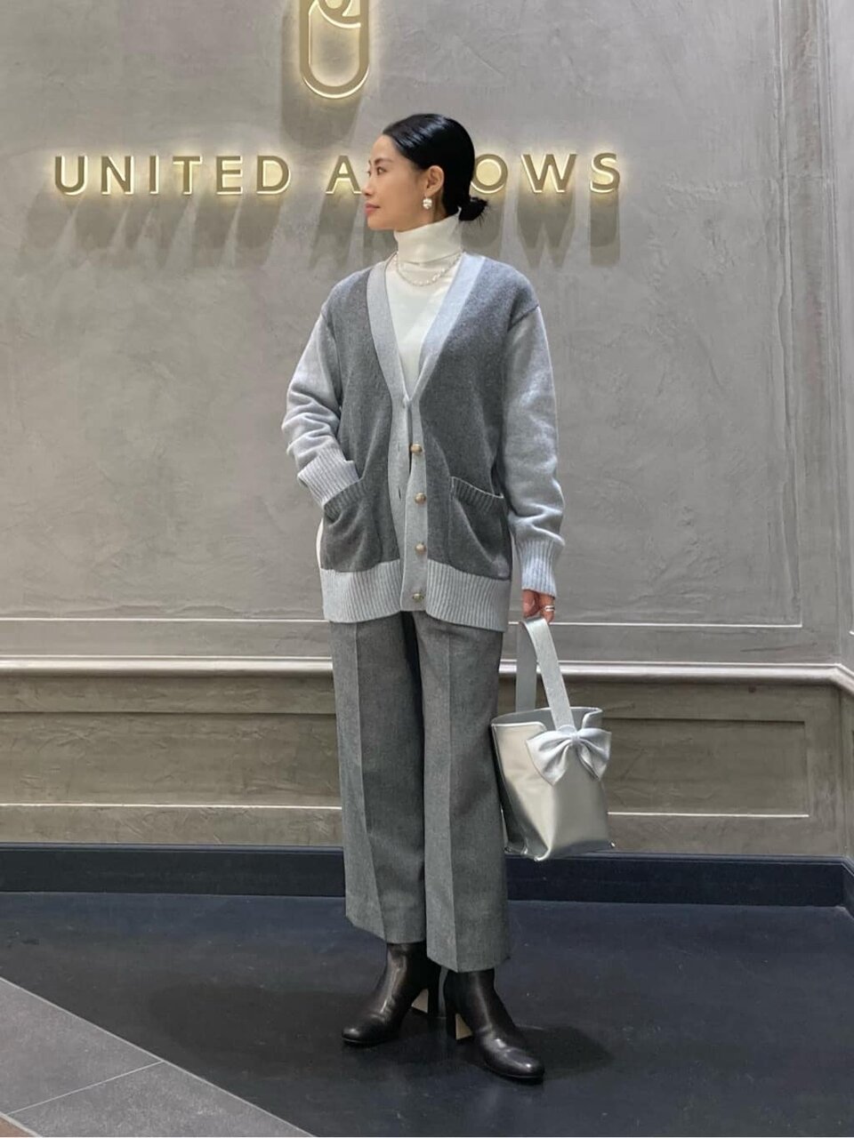 ニットカーディガンとパンツを着た女性