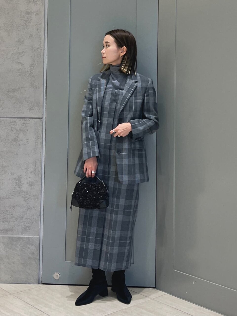 チェックジャケットのセットアップを着た女性