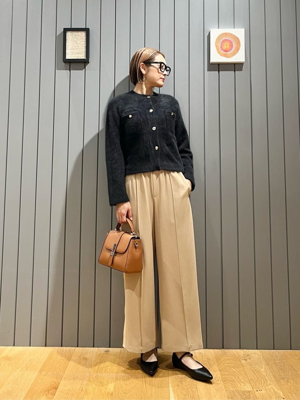 ニットカーディガンとワイドパンツの女性