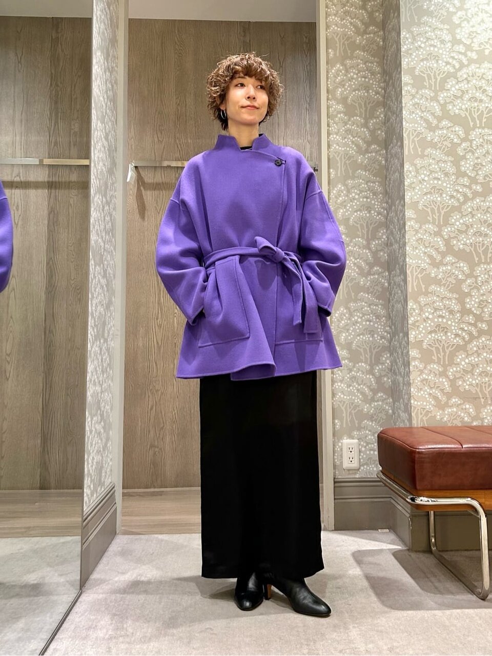 パープルのコートと黒のタイトスカートを着た女性