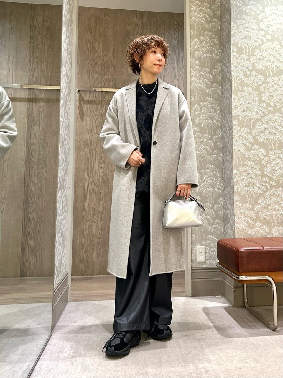 ロングコートとレザーライクパンツを着た女性