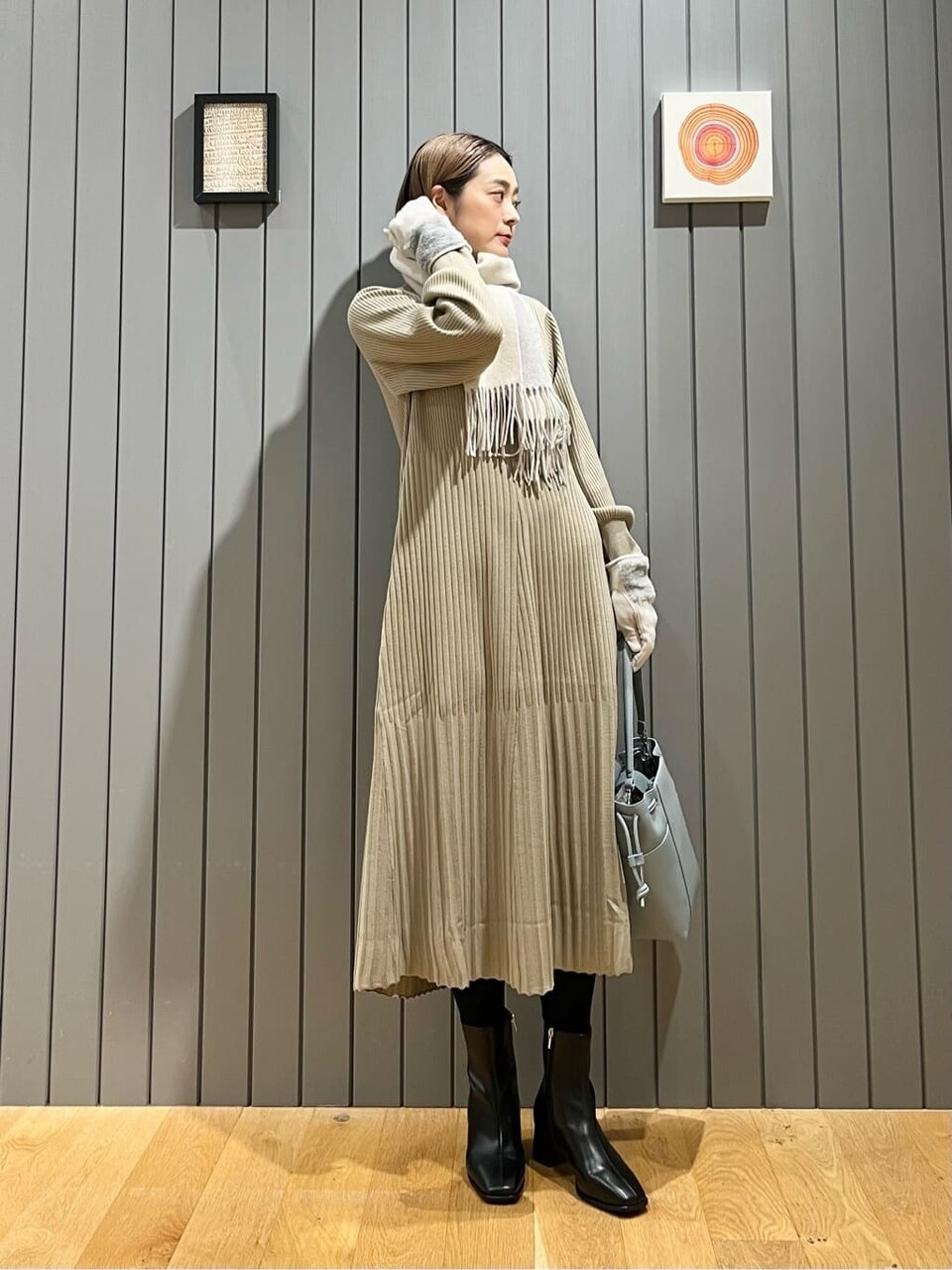 イエローのニットワンピースにカシミヤのマフラーをした女性