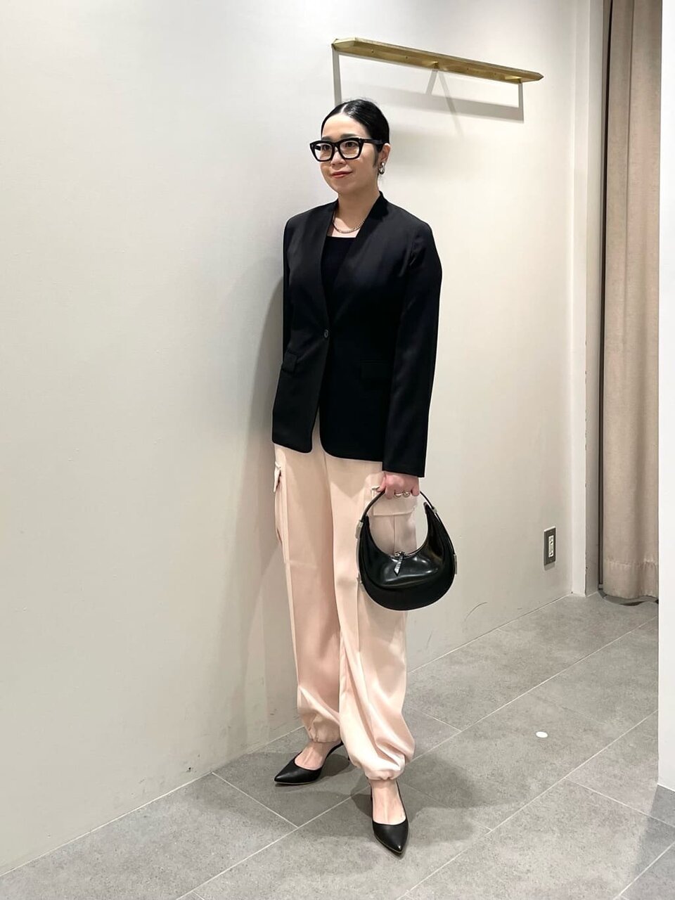 黒いジャケットとピンクのパンツを着た女性