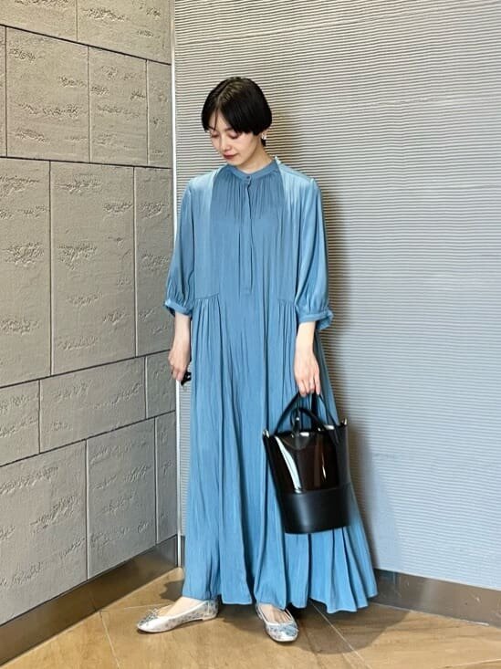 ブルーのサテンワンピースを着た女性