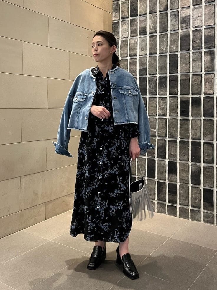 花柄のワンピースにデニムジャケットを羽織った女性