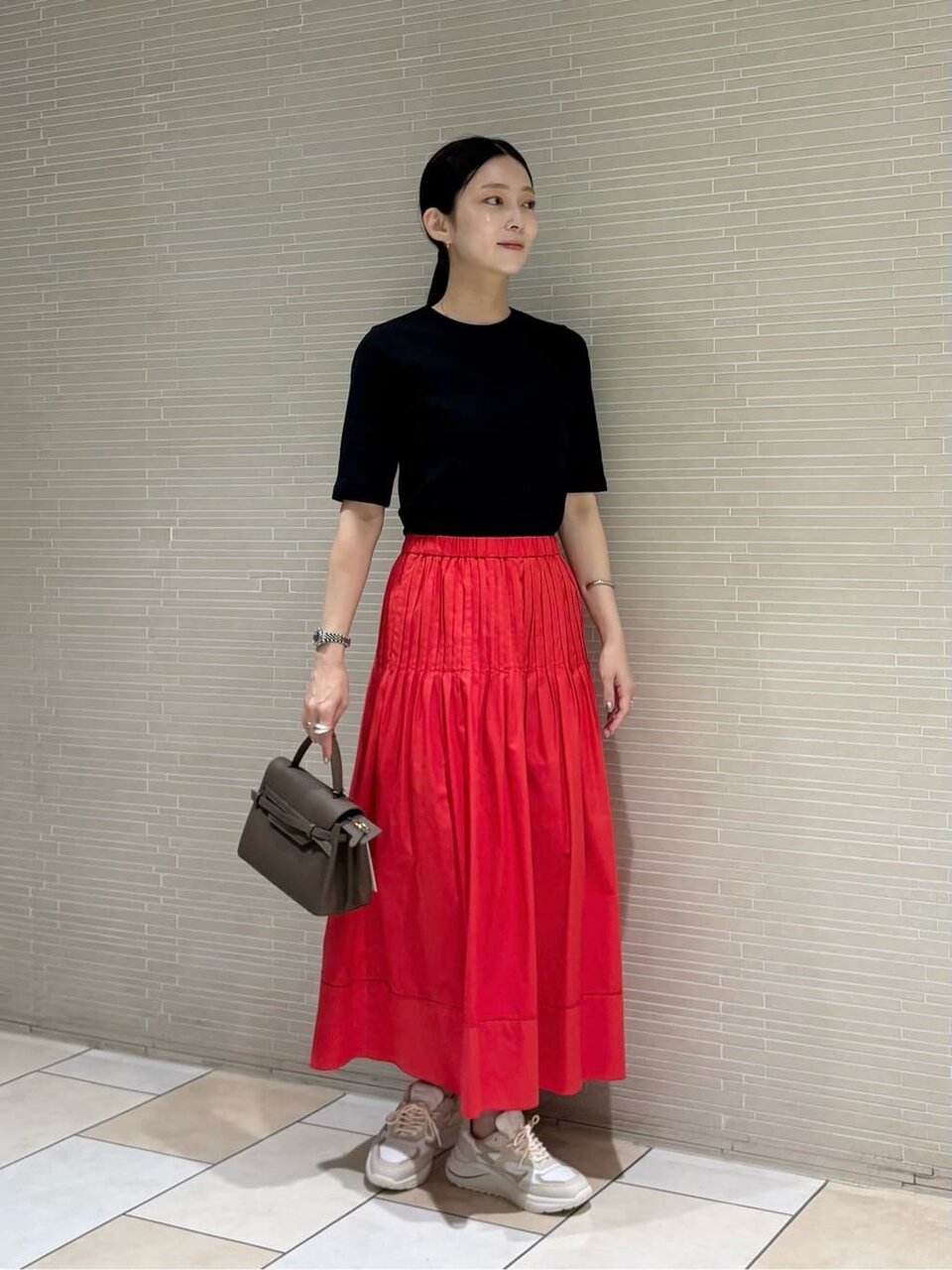 黒Tシャツと赤いスカートを着た女性