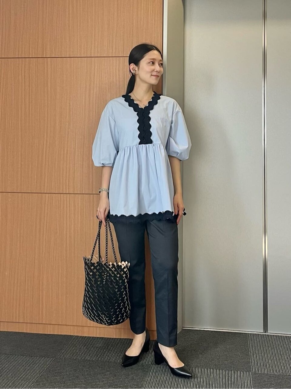 パフスリーブブラウスとテーパードパンツを着た女性