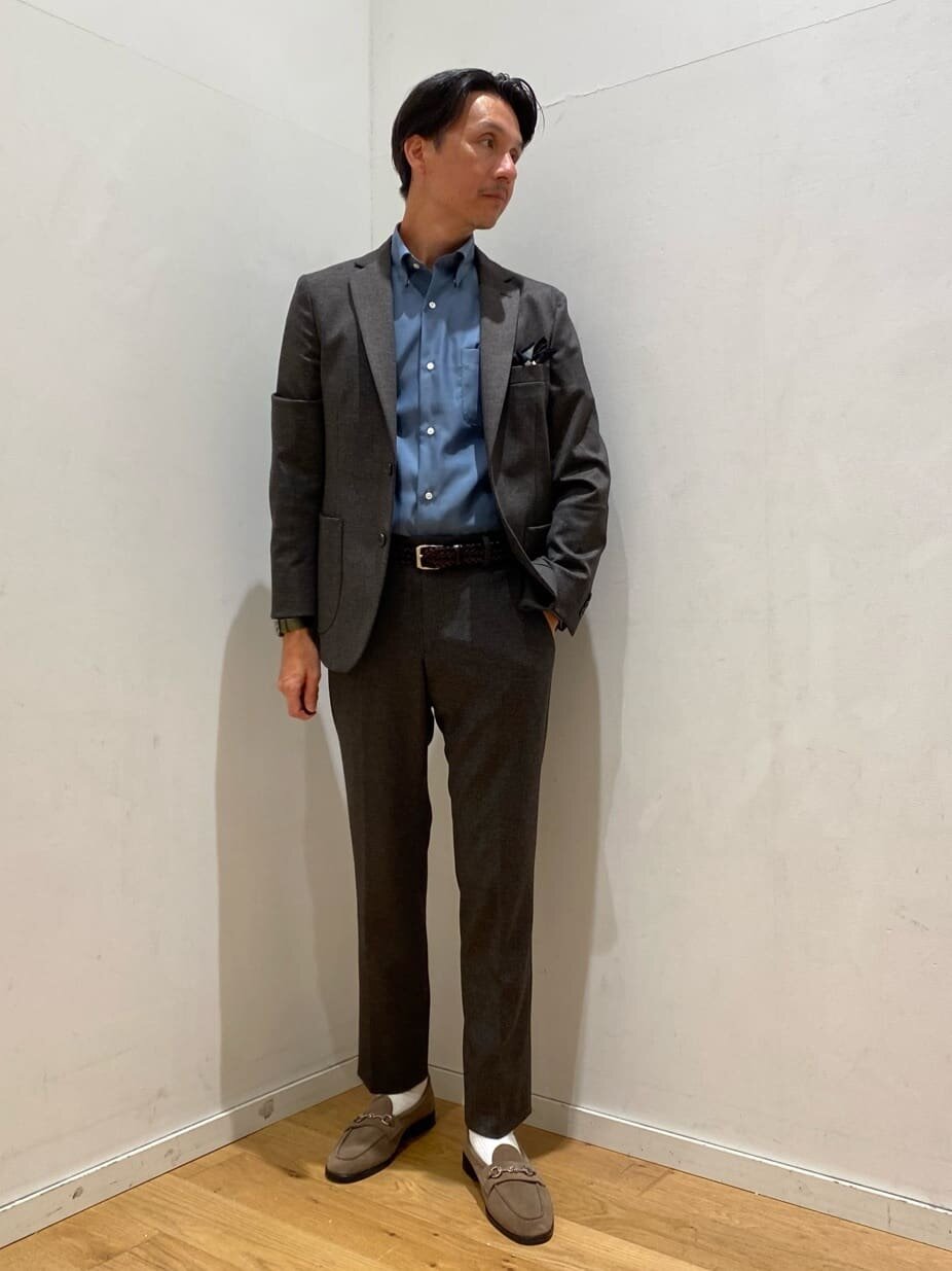 ダークブラウンのセットアップを着た男性