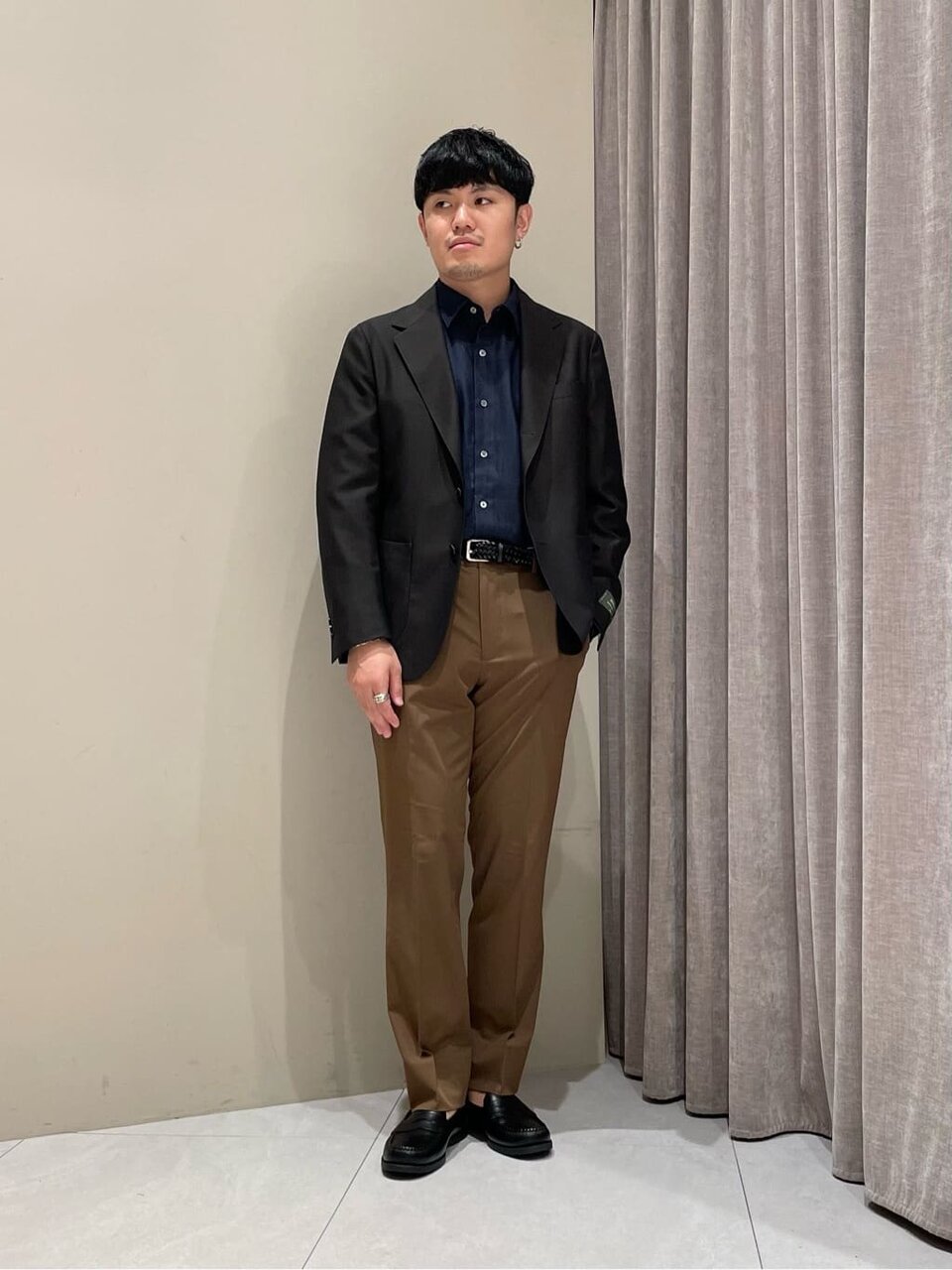 ブラウンのスラックスをはいた男性