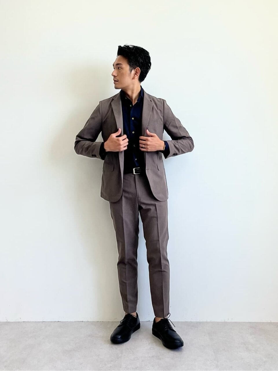 ダークブラウンのセットアップを着た男性