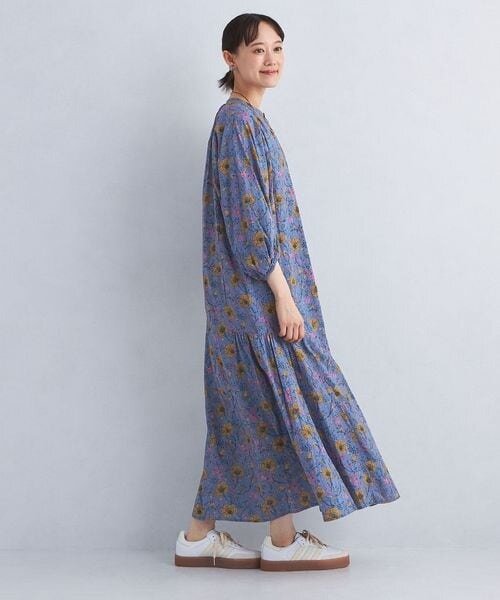 ローカットタイプのスニーカーを履いているワンピースの女性