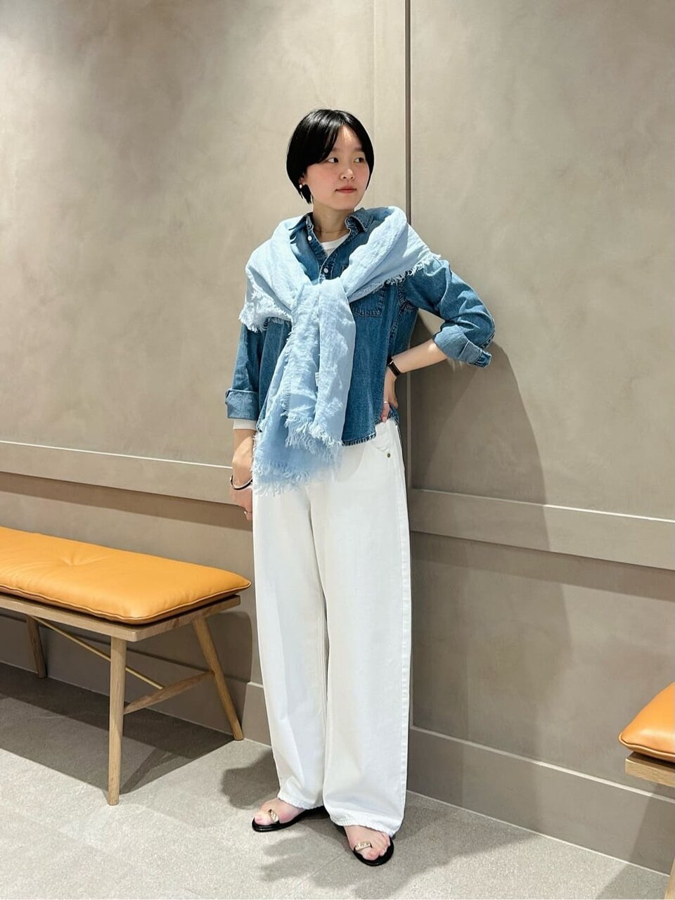 デニムシャツと白いパンツを着た女性