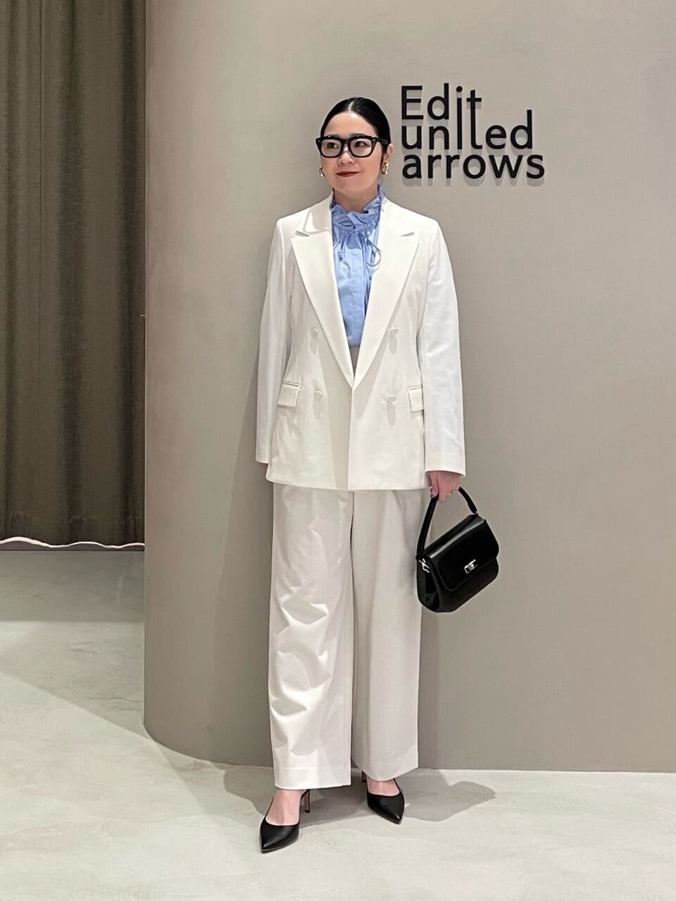 白いジャケットと白いパンツを着た女性